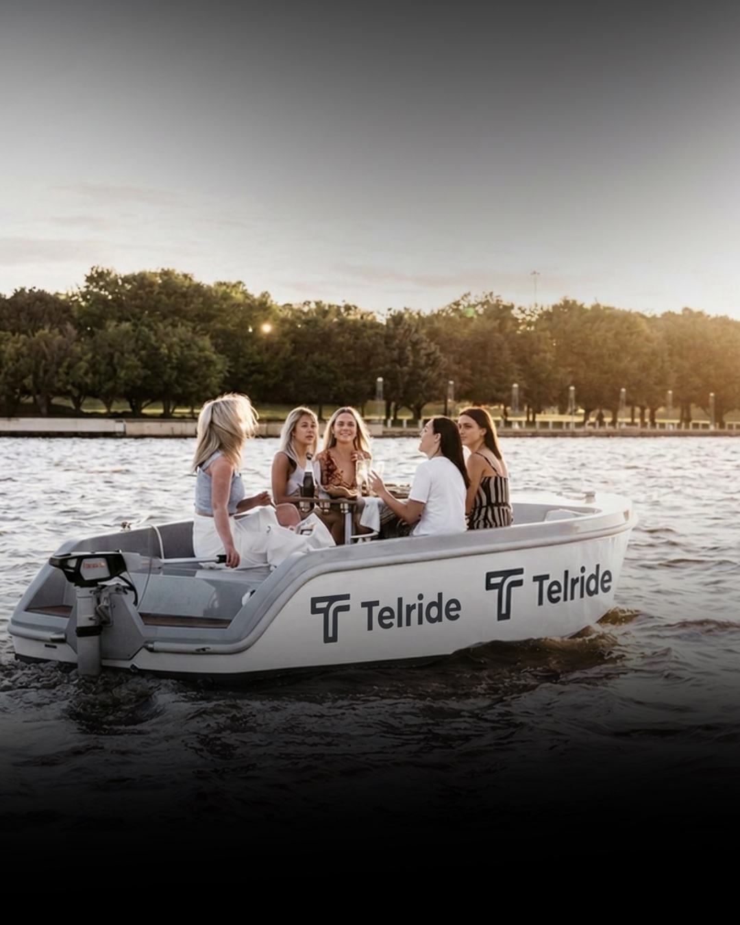 Guests aboard a white Telride water taxi on the harbour at golden hour.